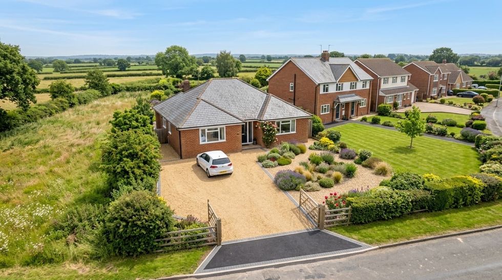Aerial view of a gravel driveway with planted borders at a bungalow